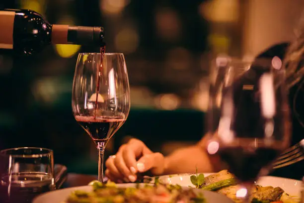 Pouring white wine at a luxury restaurant table